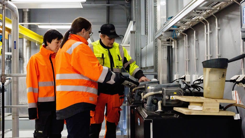 Vesihuoltoalan ammattitaitoa: kolme ihmistä työskentelee vesilaitoksella