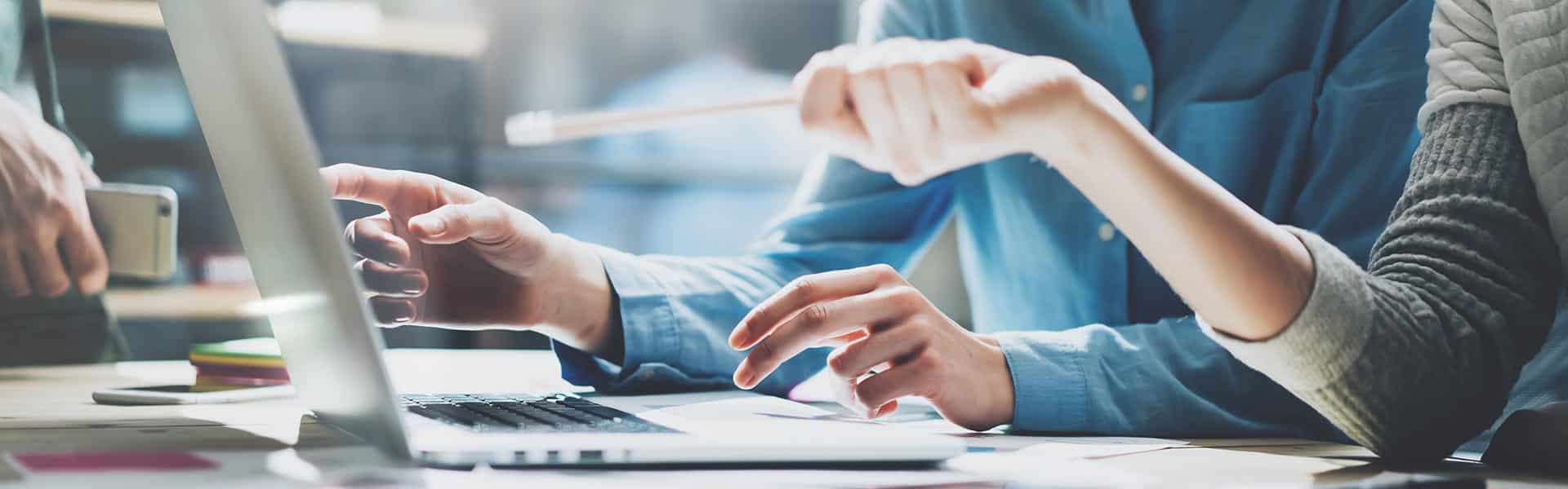 Ihmiset keskustelevat tietokoneen äärellä.