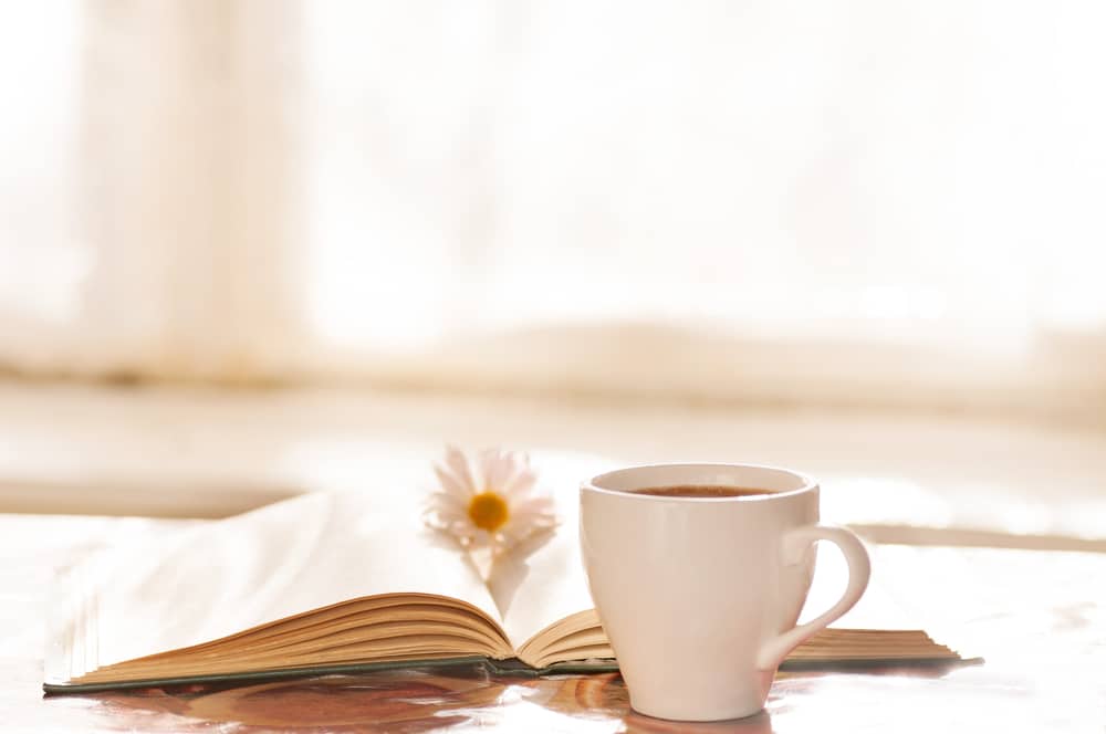 Kahvikuppi ja kirja.